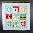 Colorful quilt with geometric patterns hanging on a dark wall