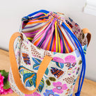 Colorful drawstring bag with floral pattern on a wooden surface