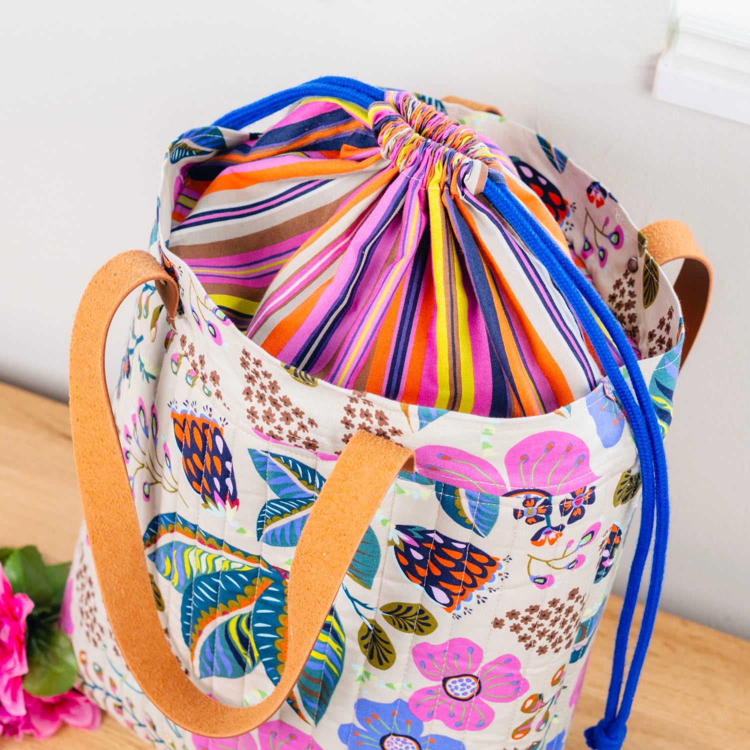 Colorful drawstring bag with floral pattern on a wooden surface