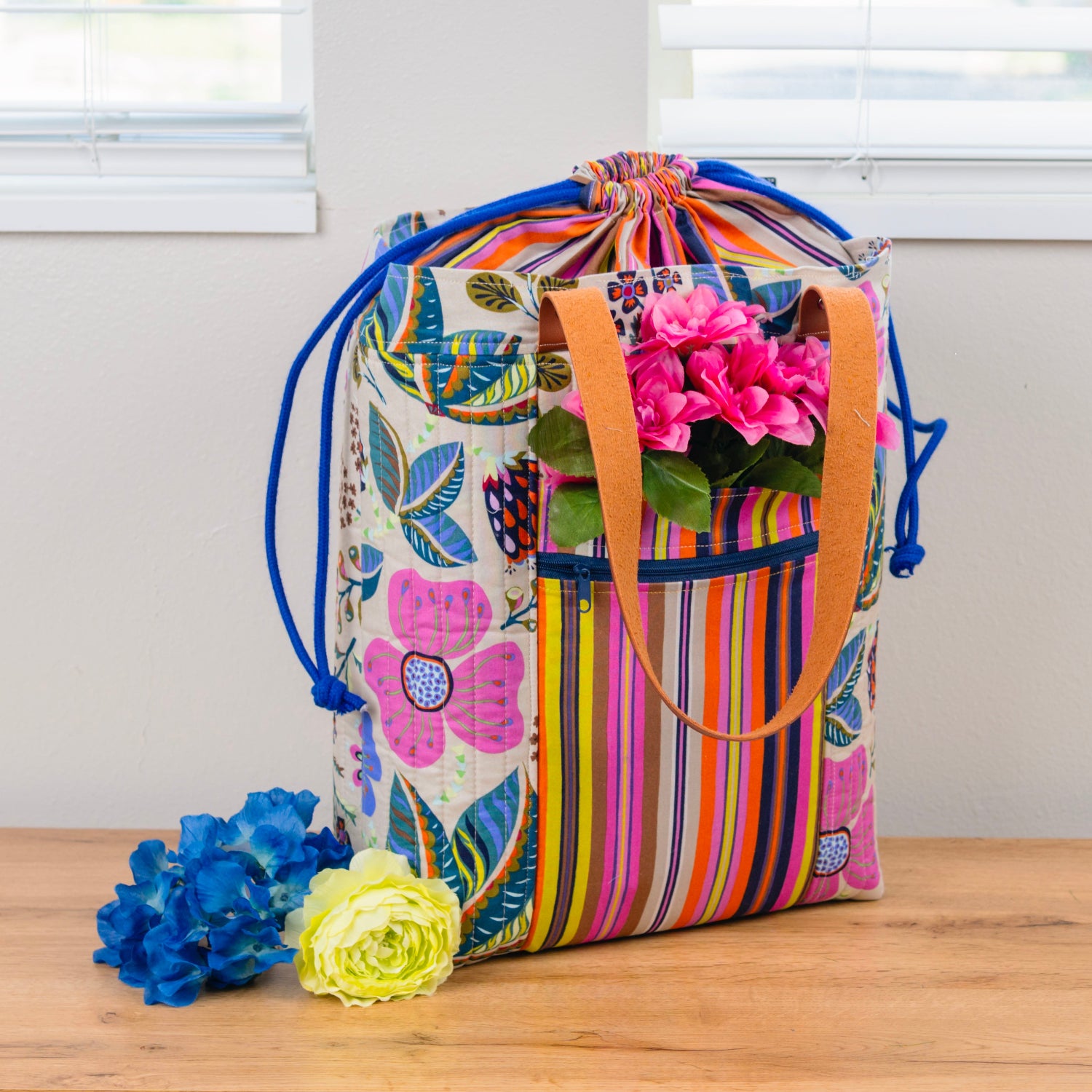 Colorful drawstring bag with floral design on a wooden surface