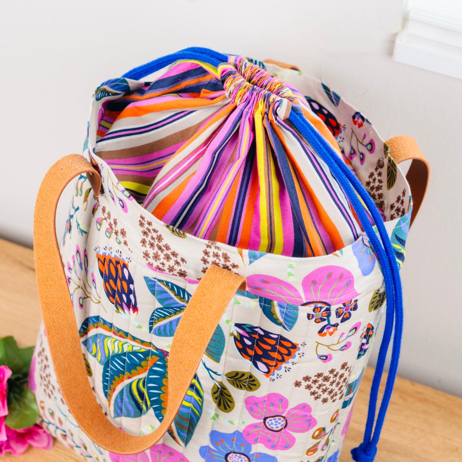 Colorful drawstring bag with floral pattern on a wooden surface