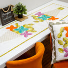 Colorful quilt with butterfly patterns on a table and chair.