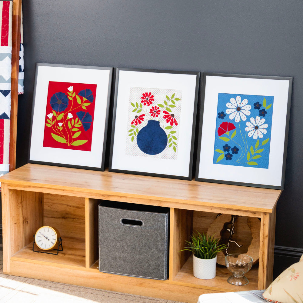 Wooden shelf with decorative items and framed artworks against a dark wall.