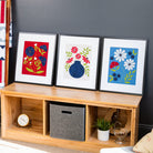 Wooden shelf with decorative items and framed artworks against a dark wall.