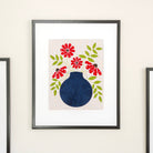 Framed artwork with a blue vase and red flowers on a white background