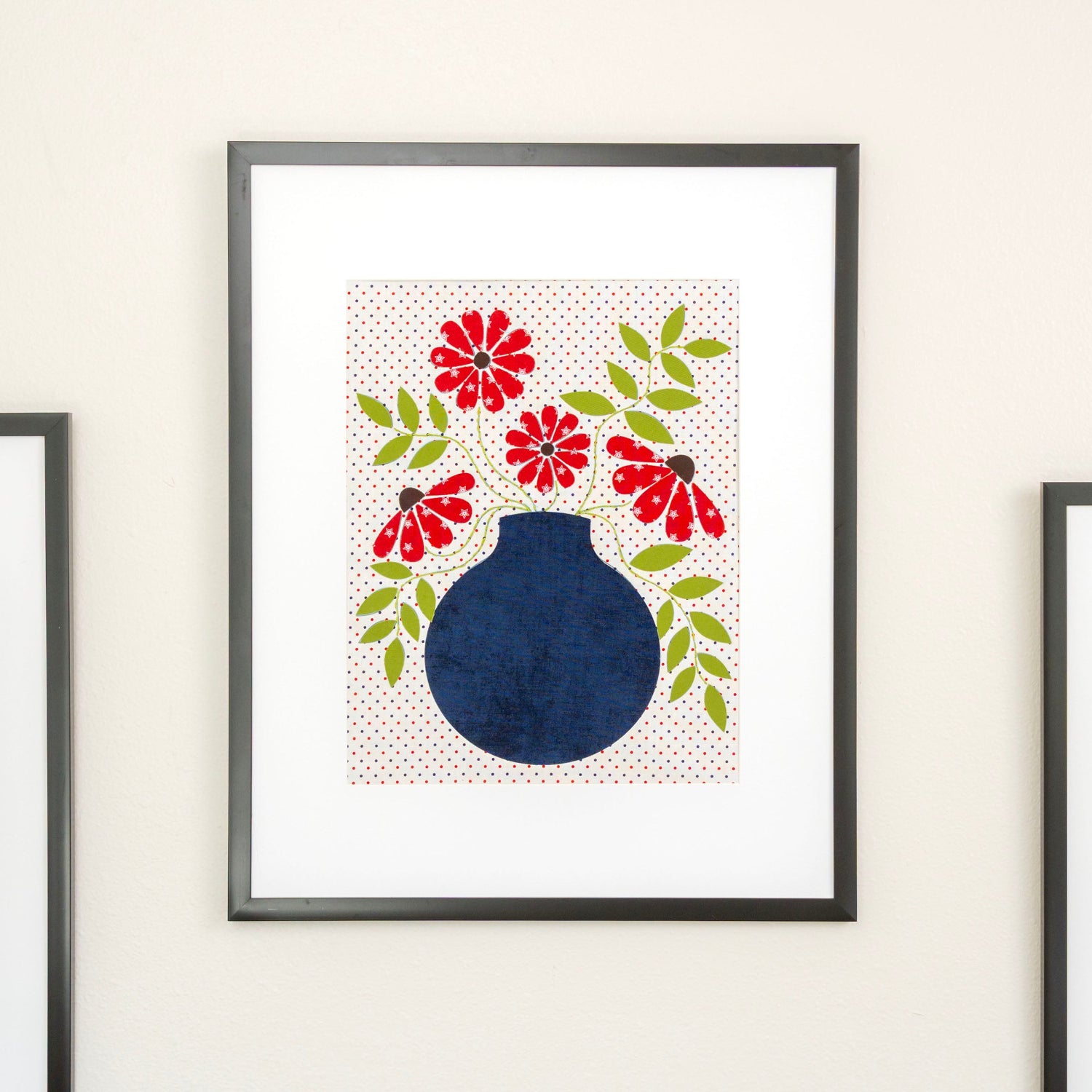 Framed artwork with a blue vase and red flowers on a white background