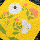 Quilt with floral patterns on a yellow background