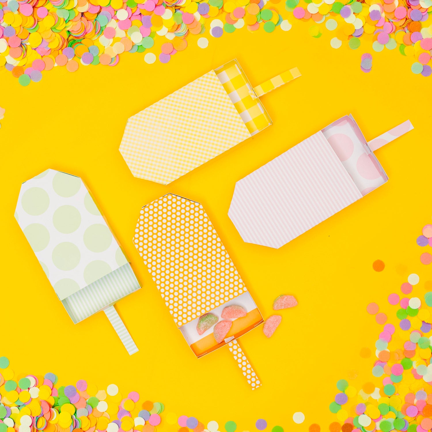 Colorful popsicles on a yellow background with confetti