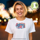 Woman wearing a white t-shirt with 'America 250' design, fireworks in the background