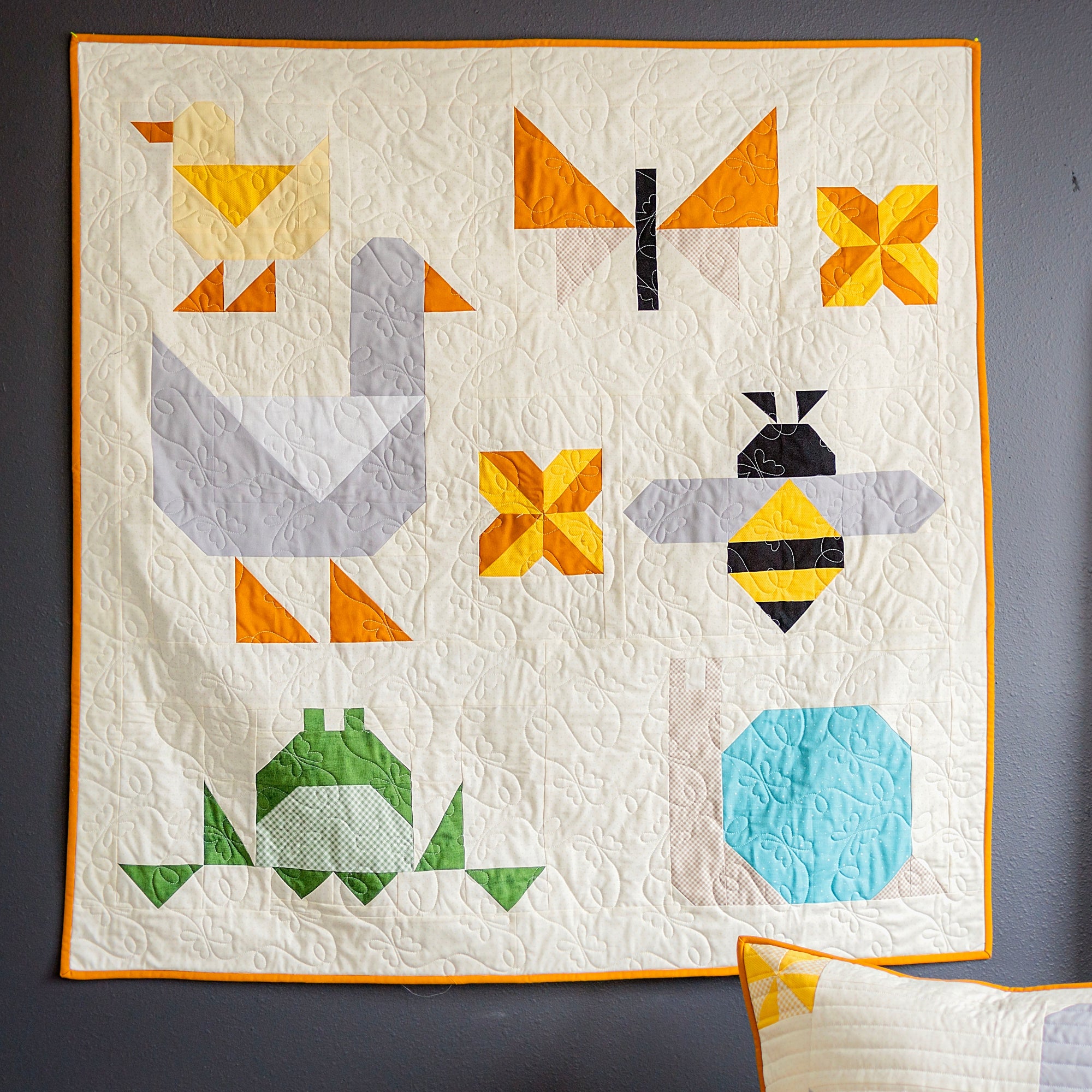 Quilt with geometric animal patterns on a gray wall