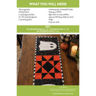 A quilt pattern cover page titled 'WHAT YOU WILL NEED' with a key and a photo of the finished table runner. The runner features a black and orange geometric pattern with white ghost motifs on a white background.