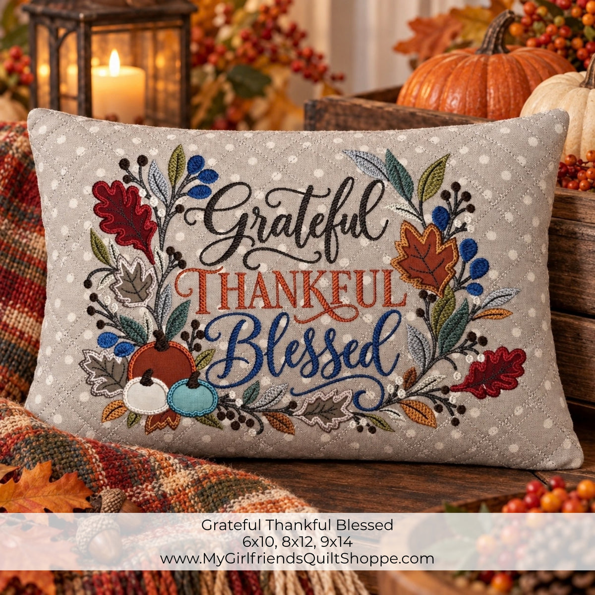 A square decorative throw pillow with a fall harvest design featuring the words 'Grateful Thankful Blessed' in black, orange, and blue script, surrounded by embroidered leaves, berries, acorns, and pumpkins. The pillow is styled on a rustic wooden surface with a plaid blanket, autumn leaves, and pumpkins in the background.
