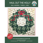 Pattern cover for 'Haul Out the Holly' wall hanging quilt by Lisa Lund for Shadow Valley Quilts, showing a green and beige geometric wreath design with a red bow and ribbon on a white background.