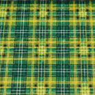 A close-up of a tartan plaid fabric pattern in green, yellow, and white, with small black square motifs at the intersections.