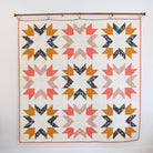 Quilt with geometric pattern hanging on a wall