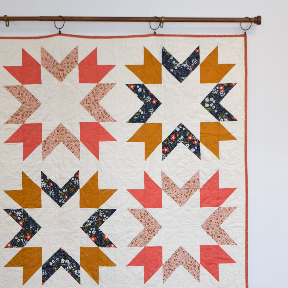 Quilt with geometric pattern hanging on a wall