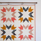 Quilt with geometric pattern hanging on a wall