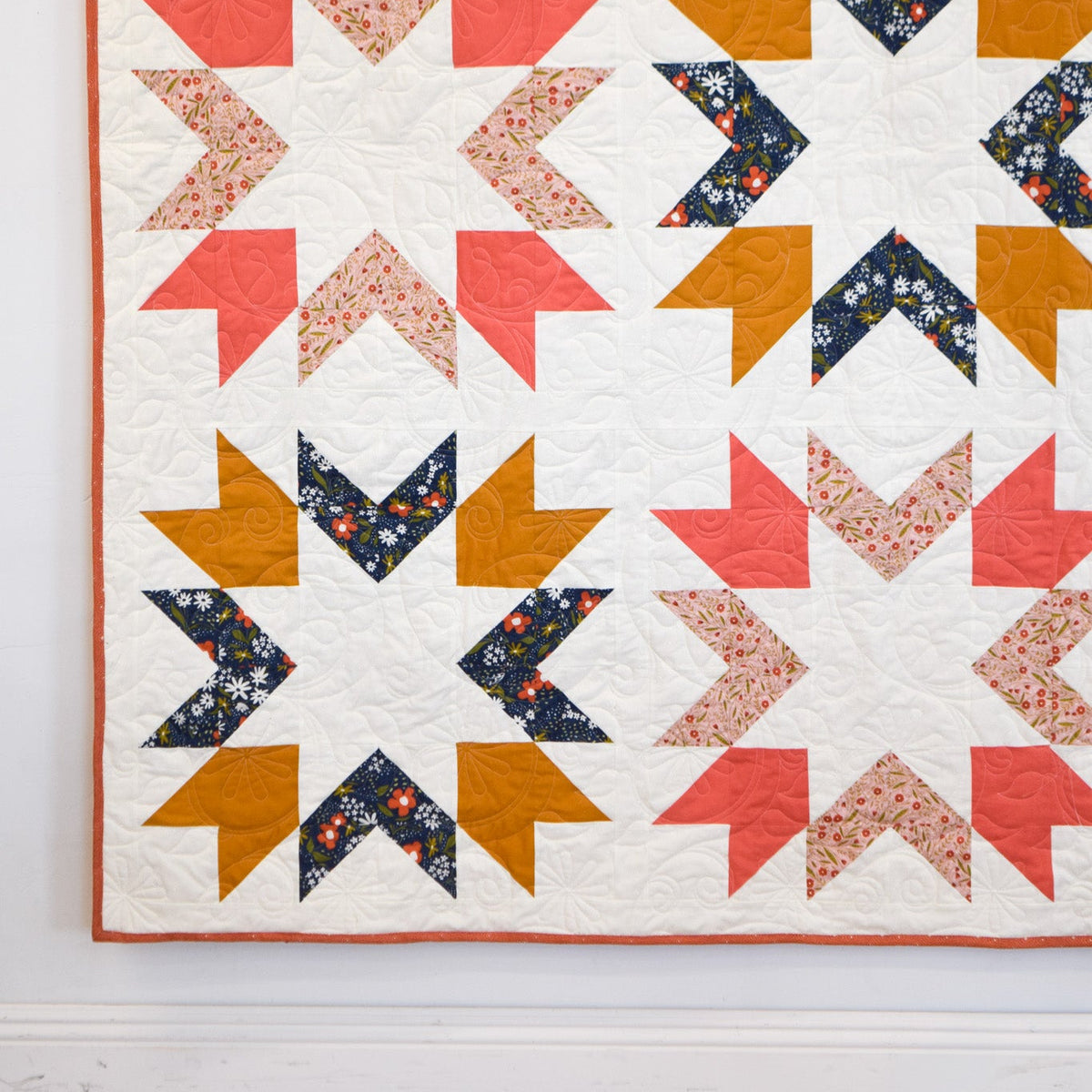 Quilt with geometric pattern on a white wall