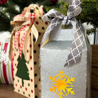 Decorative gift boxes with ribbons and a snowflake design on a wooden surface.