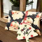 Small bag with Santa Claus design and a decorative tag on a wooden surface.