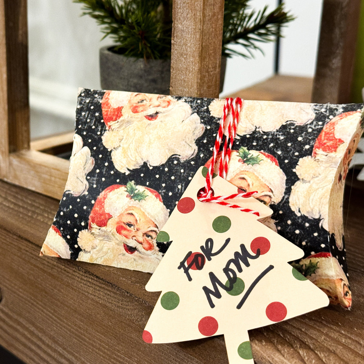 Small bag with Santa Claus design and a decorative tag on a wooden surface.