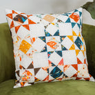 Colorful patchwork pillow on a green couch