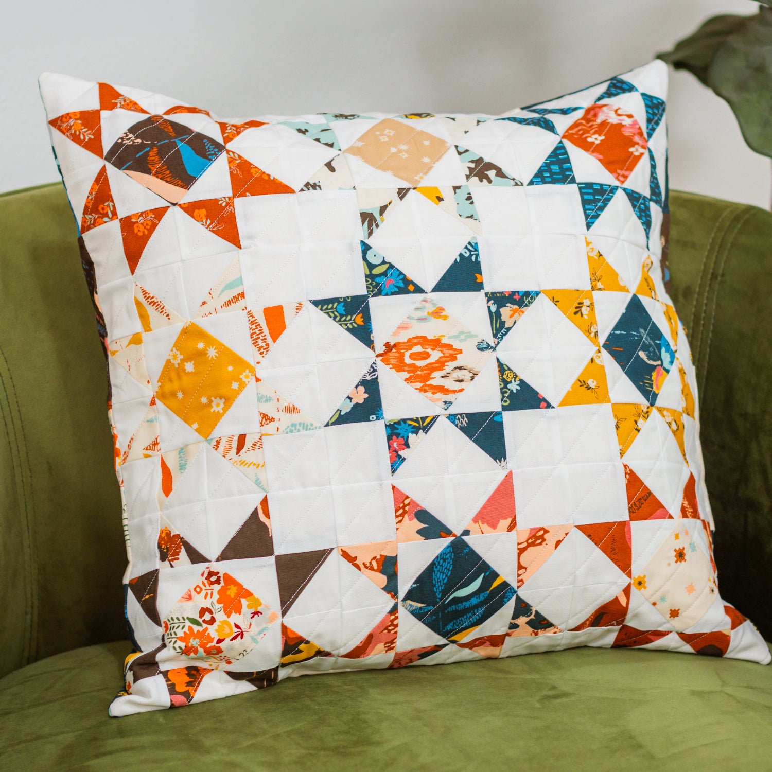Colorful patchwork pillow on a green couch