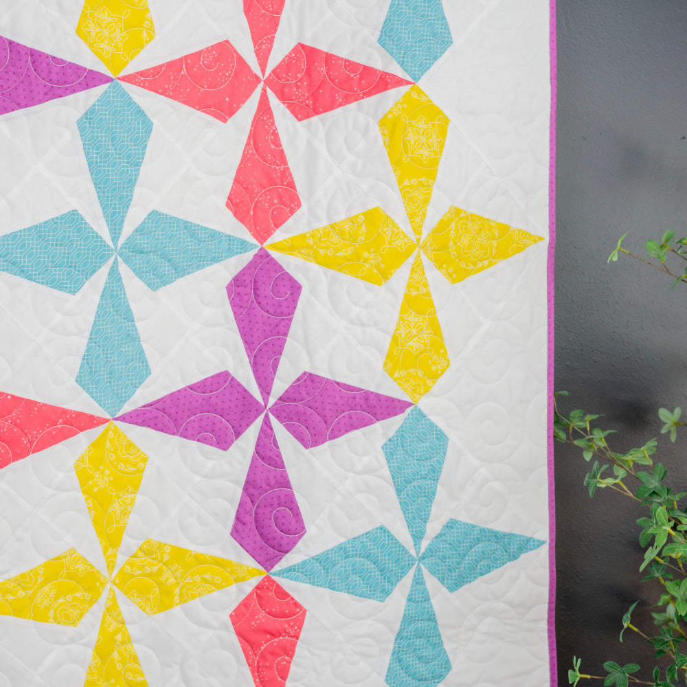 Colorful quilt with geometric pattern on a white background