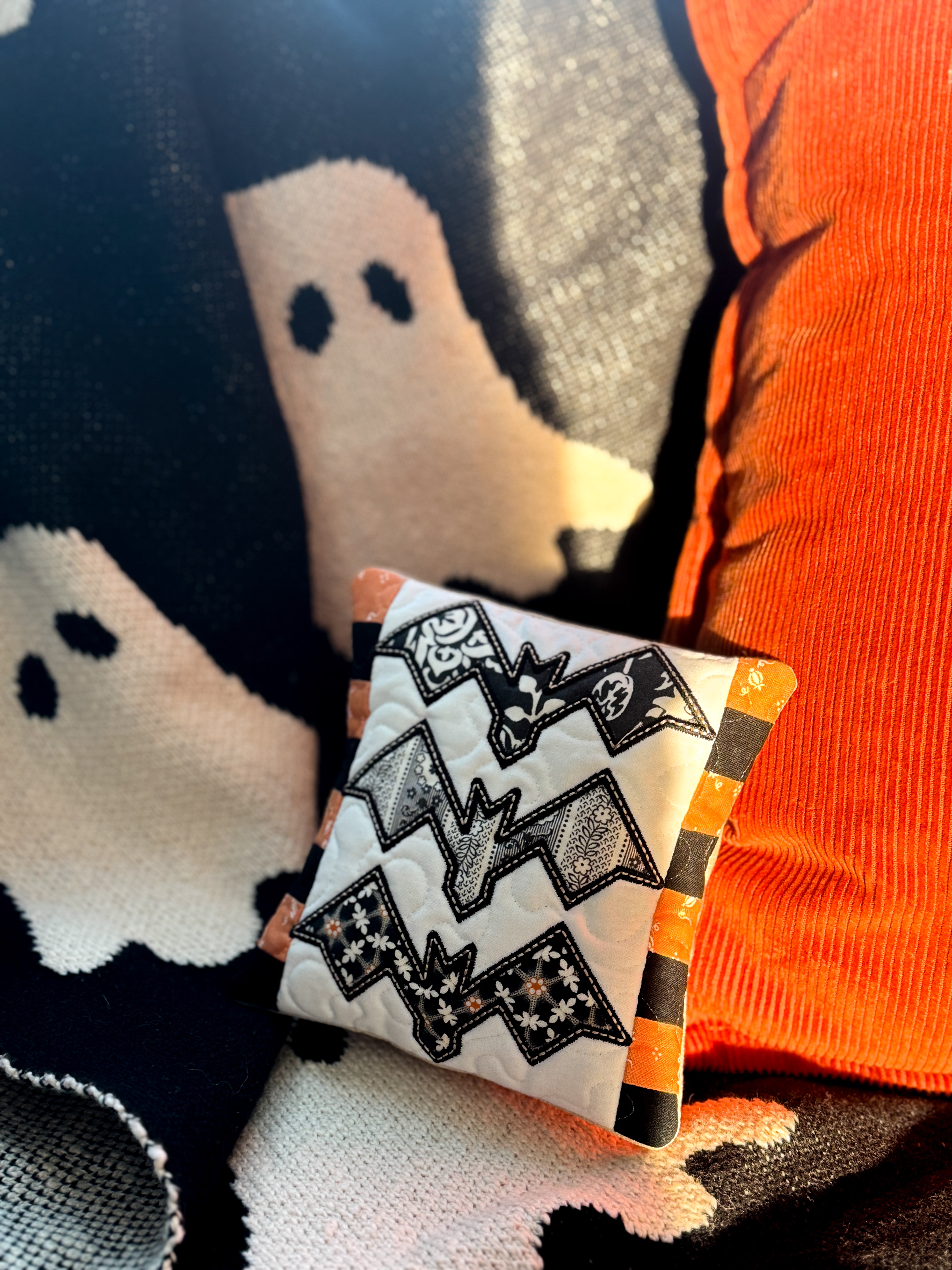 Halloween-themed pillow with ghost design on a soft surface