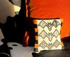 Decorative pillow with bat pattern on a black and orange background
