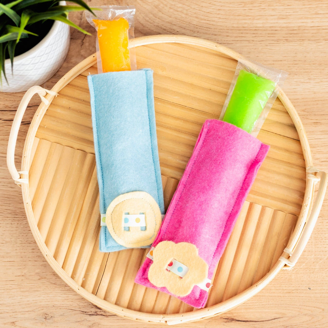 Colorful hair ties in a woven basket on a wooden surface with a plant in the background