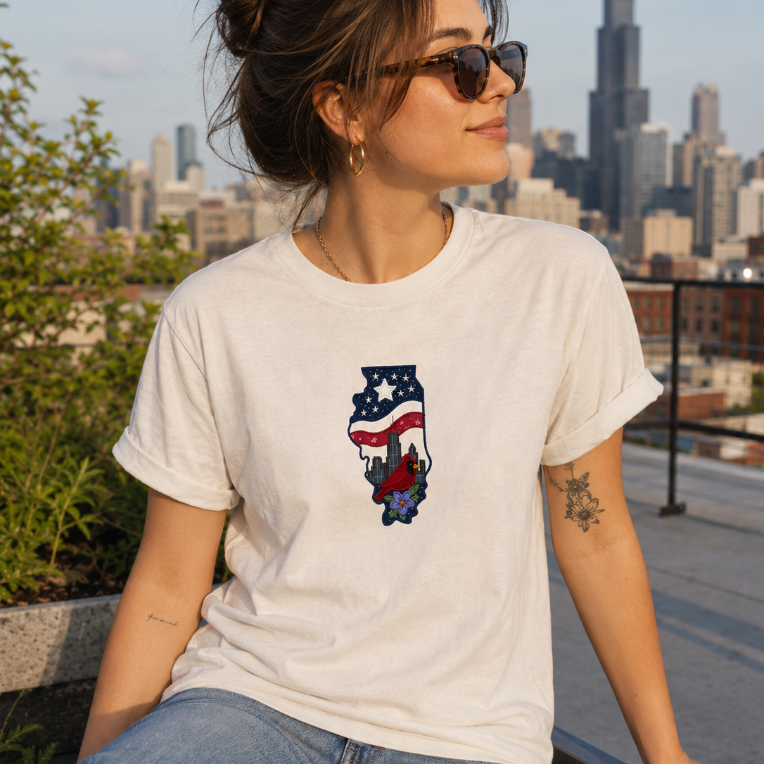 Woman wearing a white t-shirt with a graphic design, sitting in front of a city skyline.