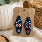 Pair of earrings on a cardboard backing with decorative elements