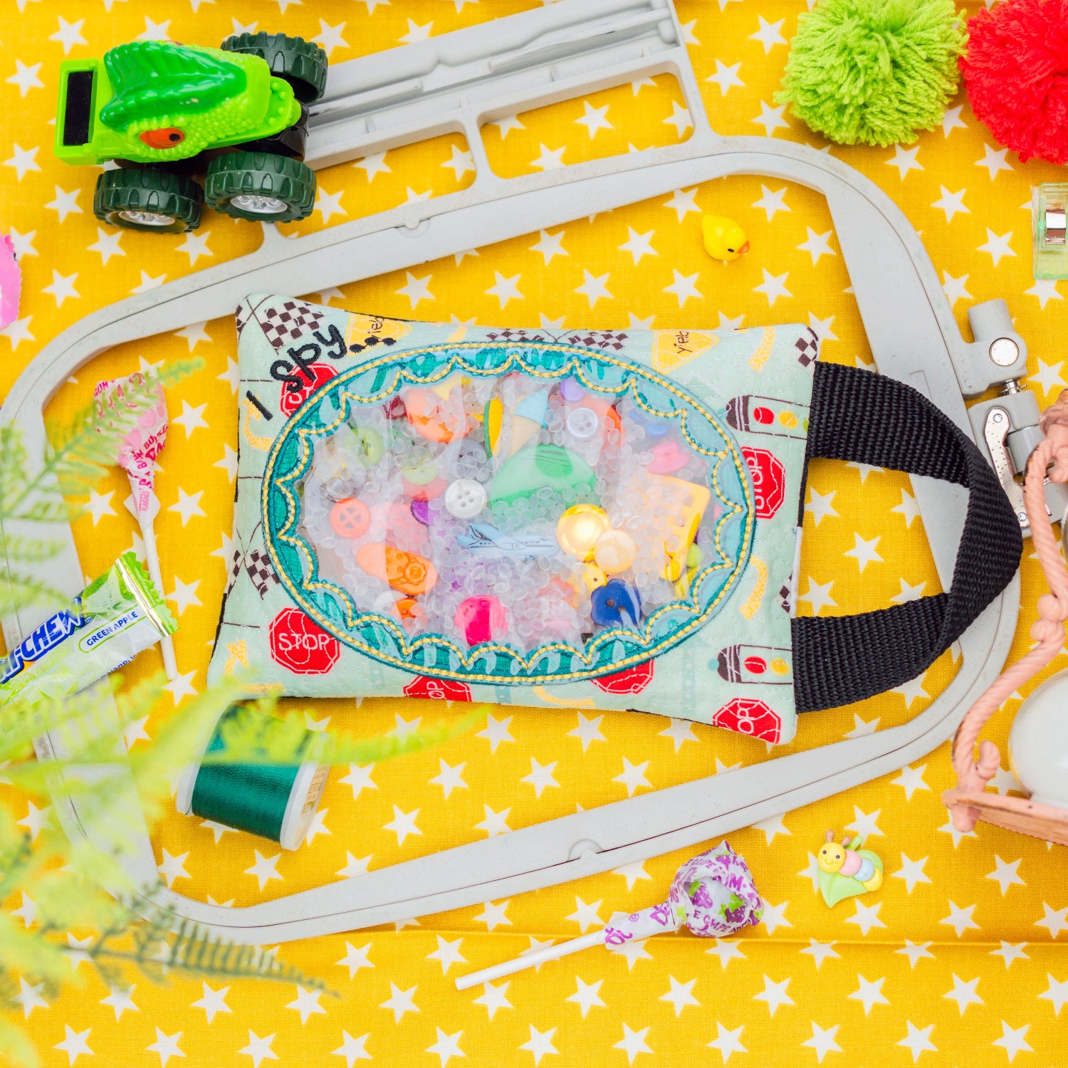 Toy car track set with colorful toys on a yellow star-patterned background
