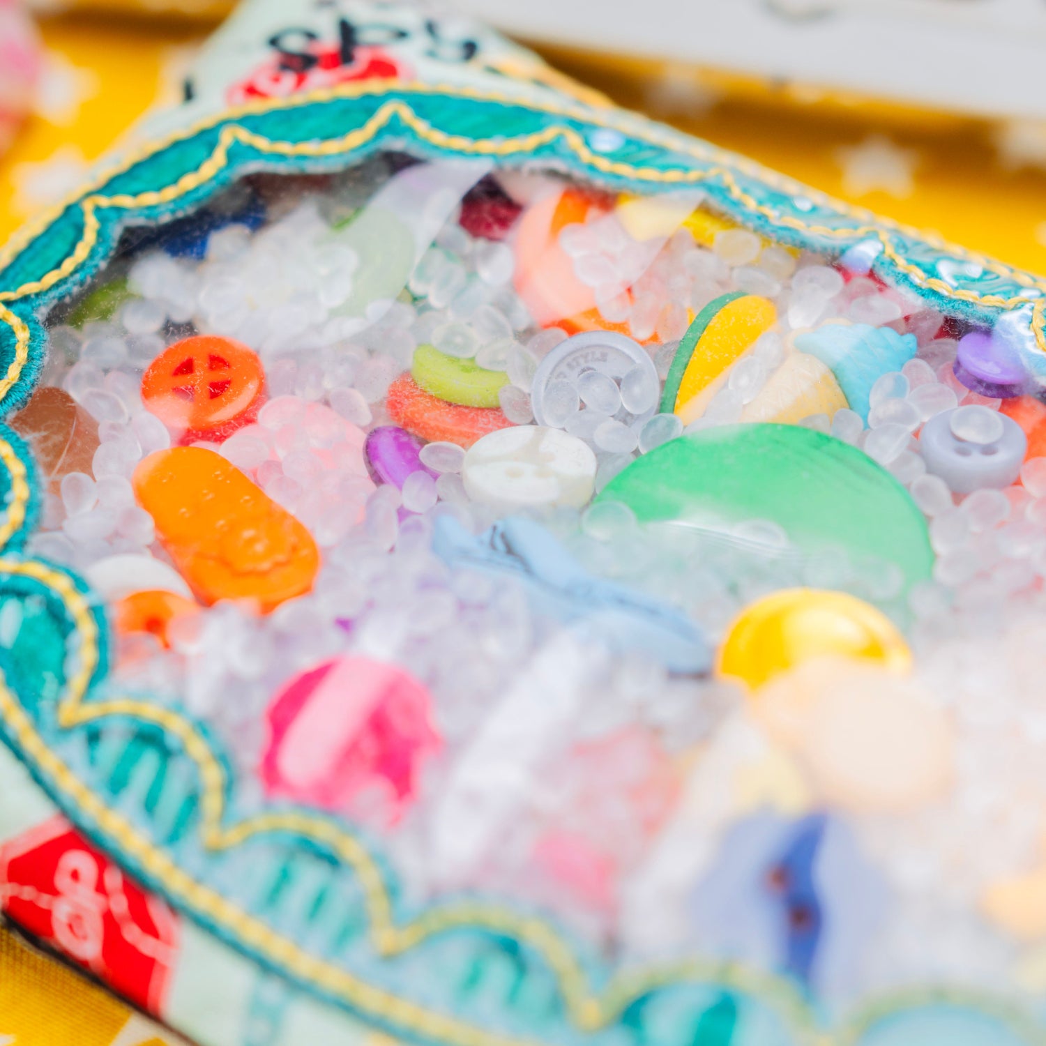 Children's toy with colorful beads and toys on a yellow background with stars