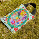Colorful pouch with decorative elements on a grassy background