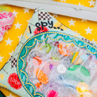 Colorful 'I Spy' game with plastic toys on a yellow background
