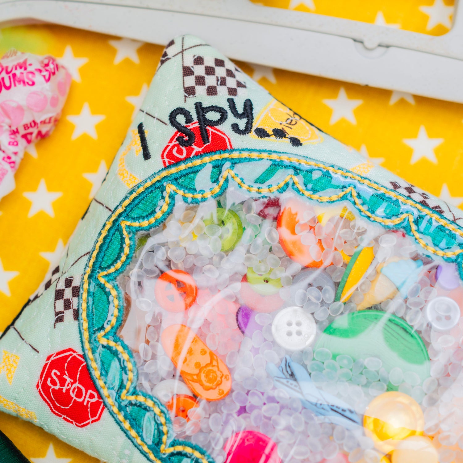 Colorful 'I Spy' game with plastic toys on a yellow background