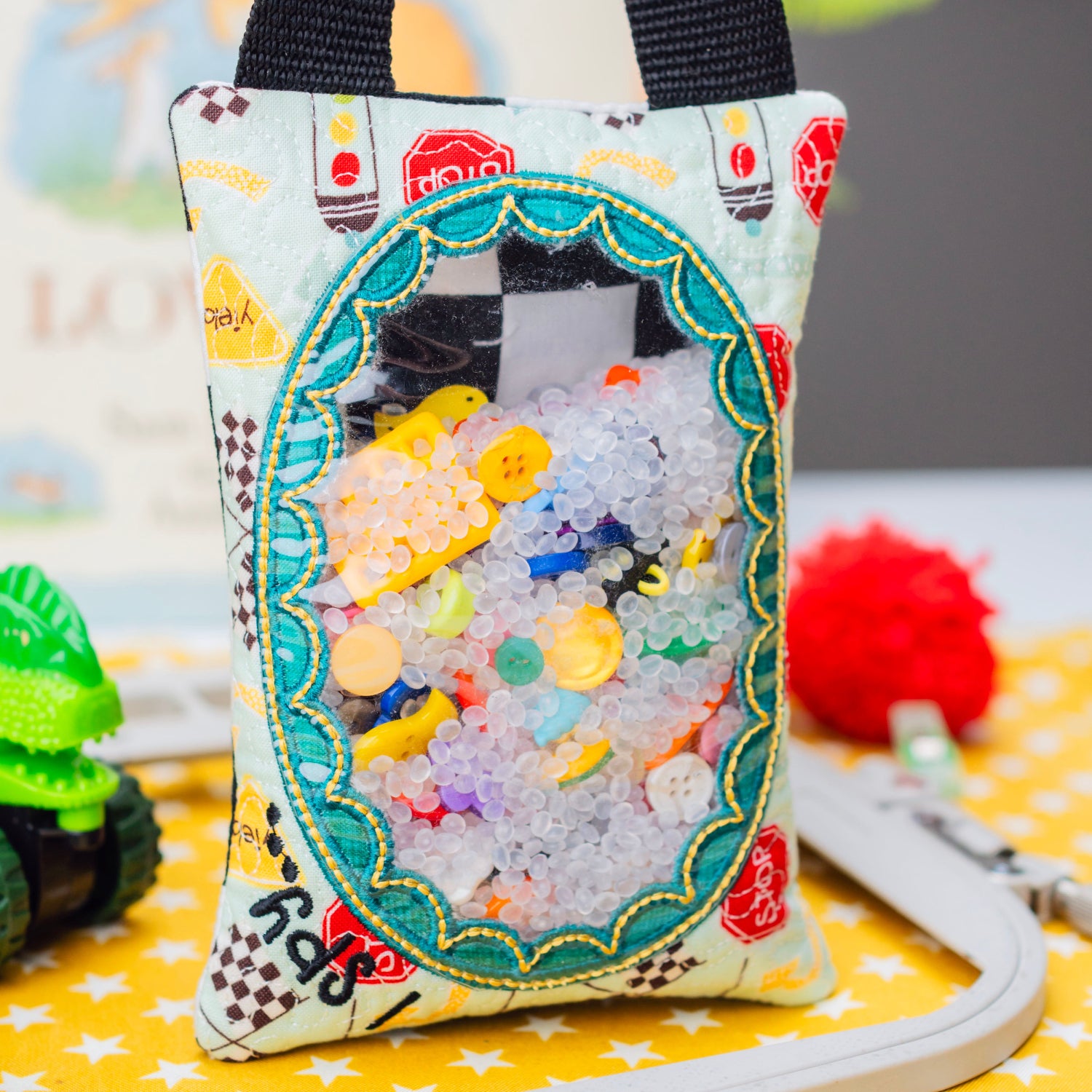 Decorative fabric pouch with colorful design on a yellow surface