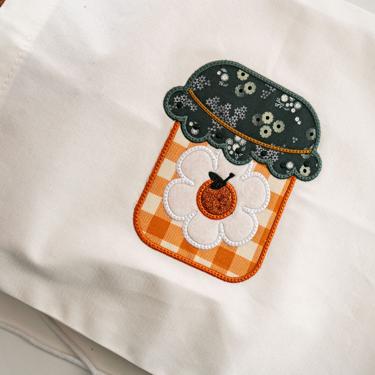Embroidered patch with a pumpkin design on a white fabric background