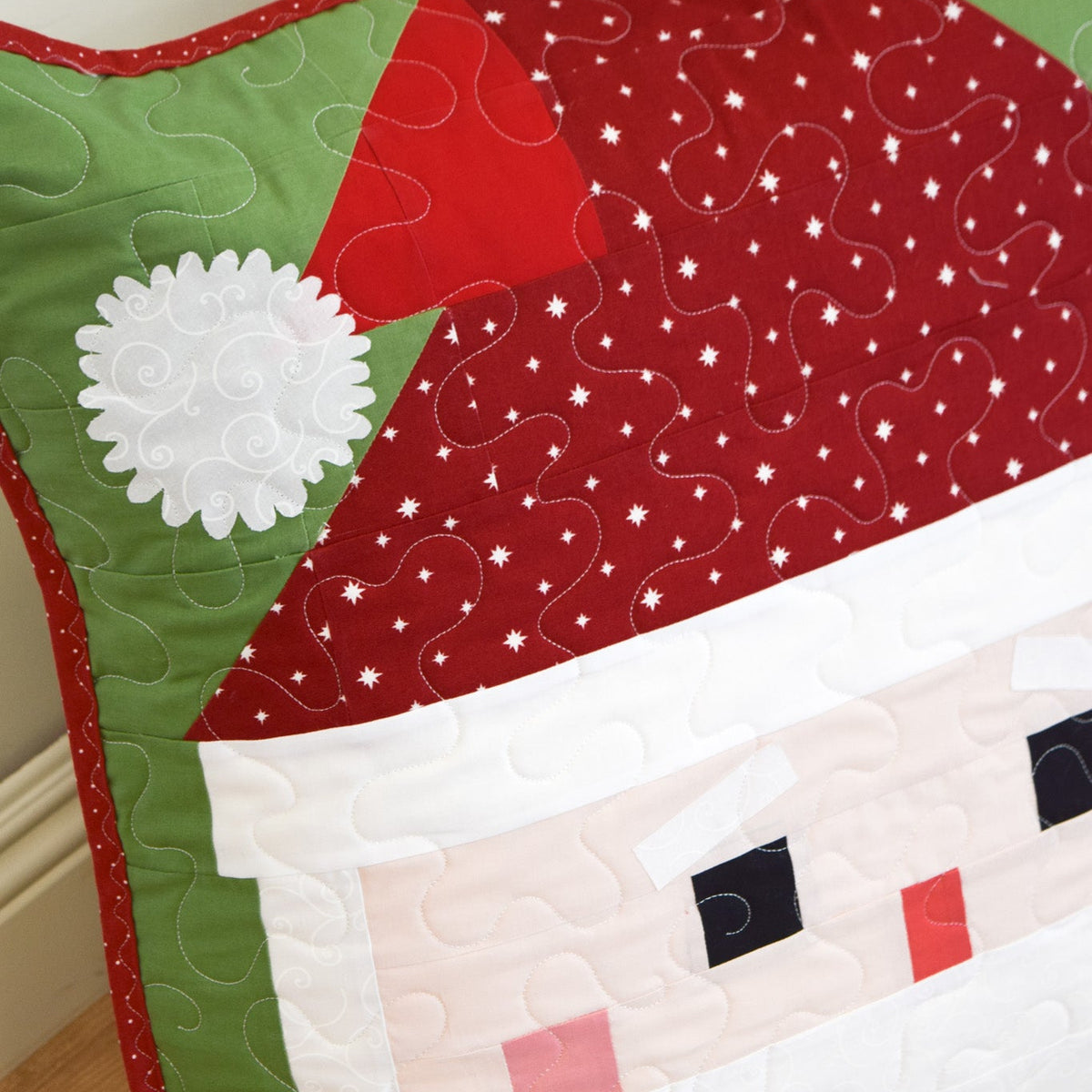 Quilted Santa Claus design on a wooden surface