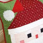 Quilted Santa Claus design on a wooden surface