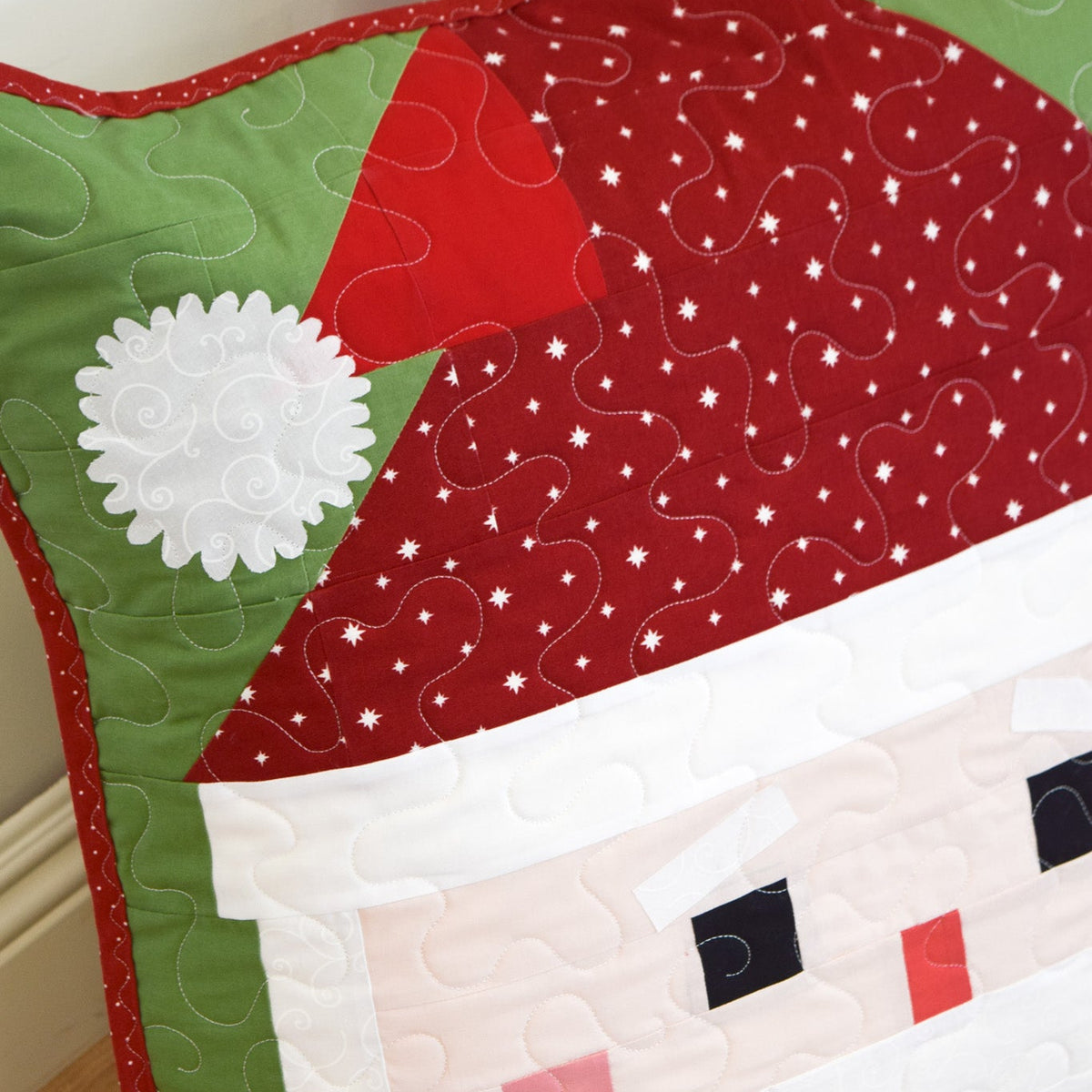 Quilted Santa Claus design on a wooden surface