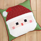 Decorative pillow with Santa Claus face design on a wooden floor