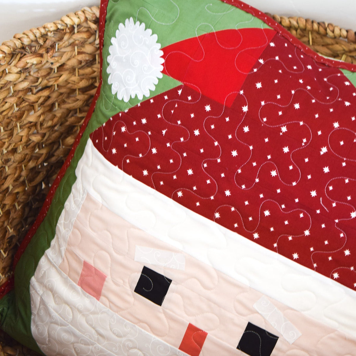 Quilted pillow with a Santa Claus design on a woven surface