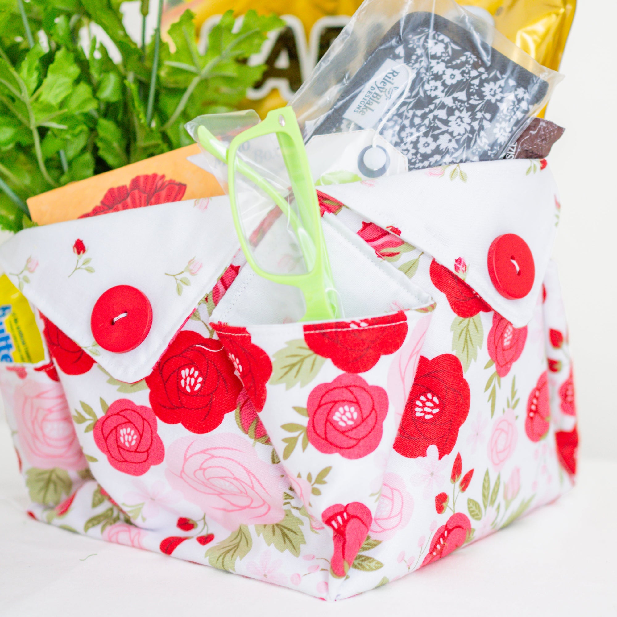 Floral-patterned fabric basket with a clear lid on a white background