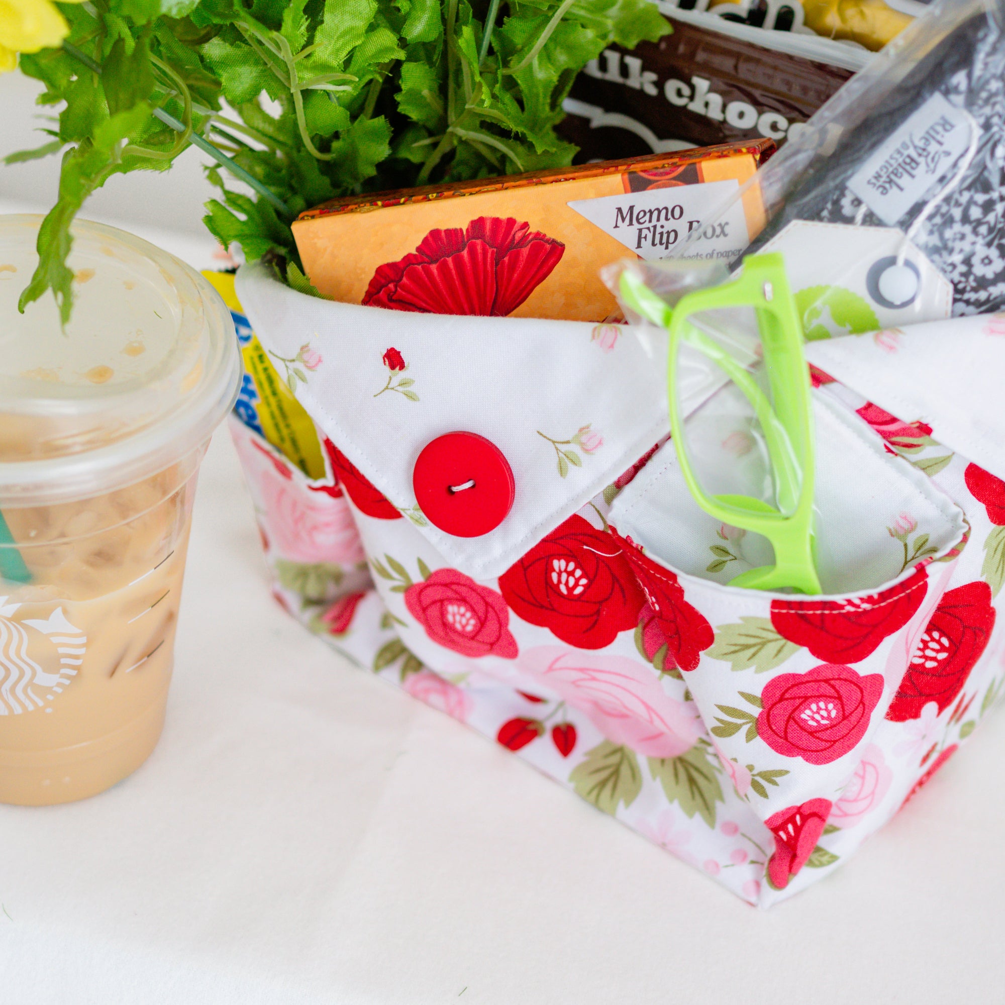 Floral-patterned snack bag with a drink and snacks on a white surface