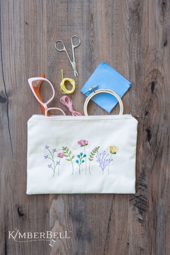 Canvas cream zipper pouch with embroidered flowers on it