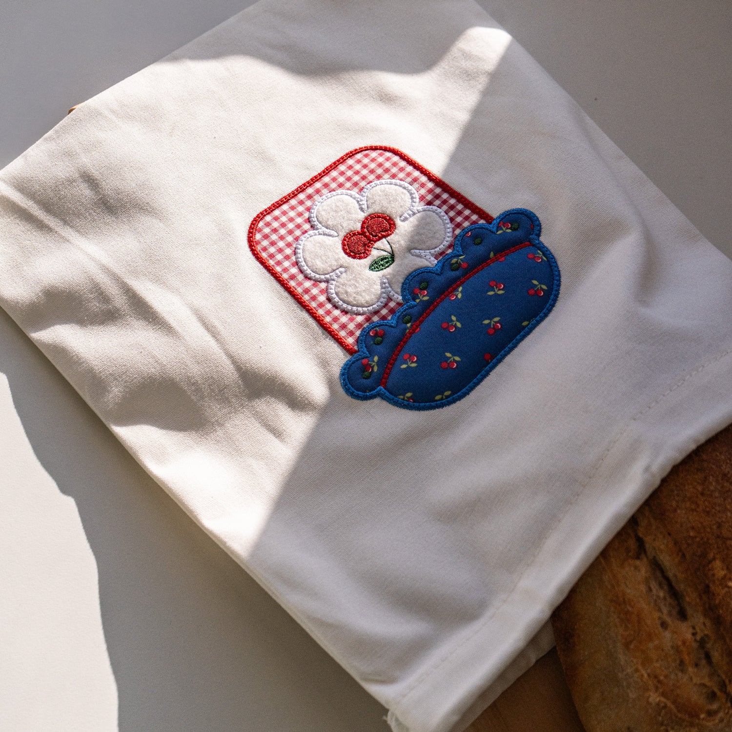 White towel with embroidered design on a wooden surface