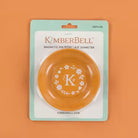 Orange magnetic pin bowl with floral design on packaging against an orange background